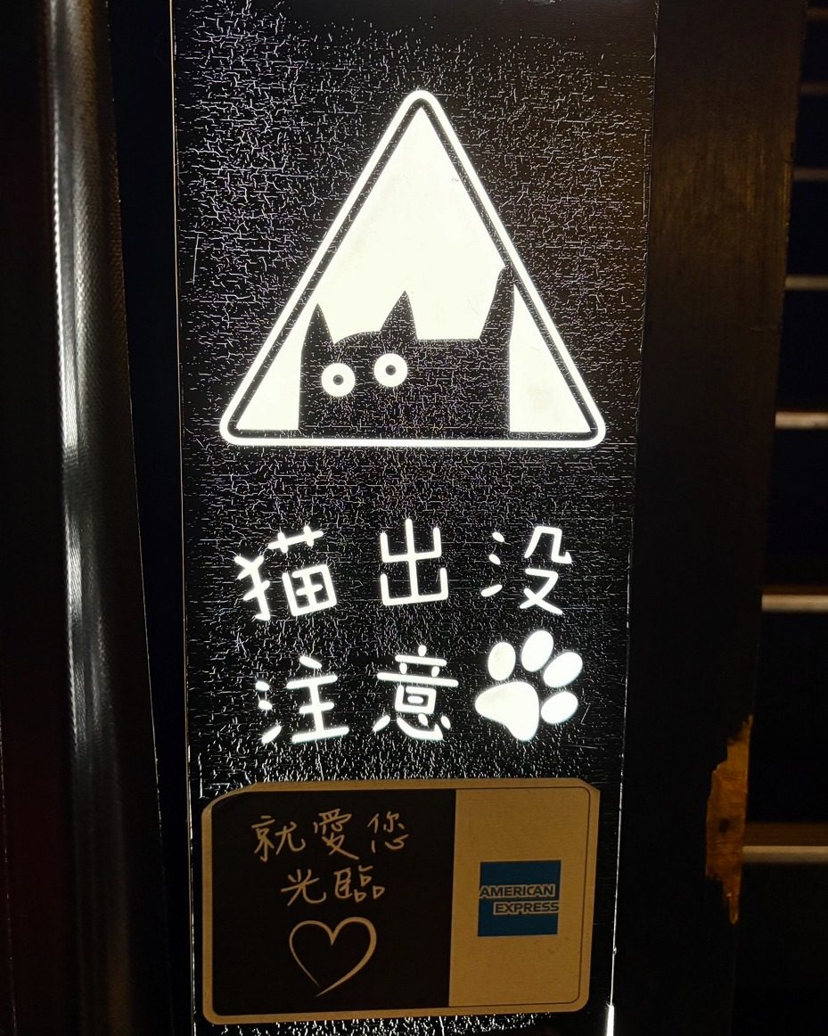 A sign by the stairs reading 猫出没注意 — caution, cats about