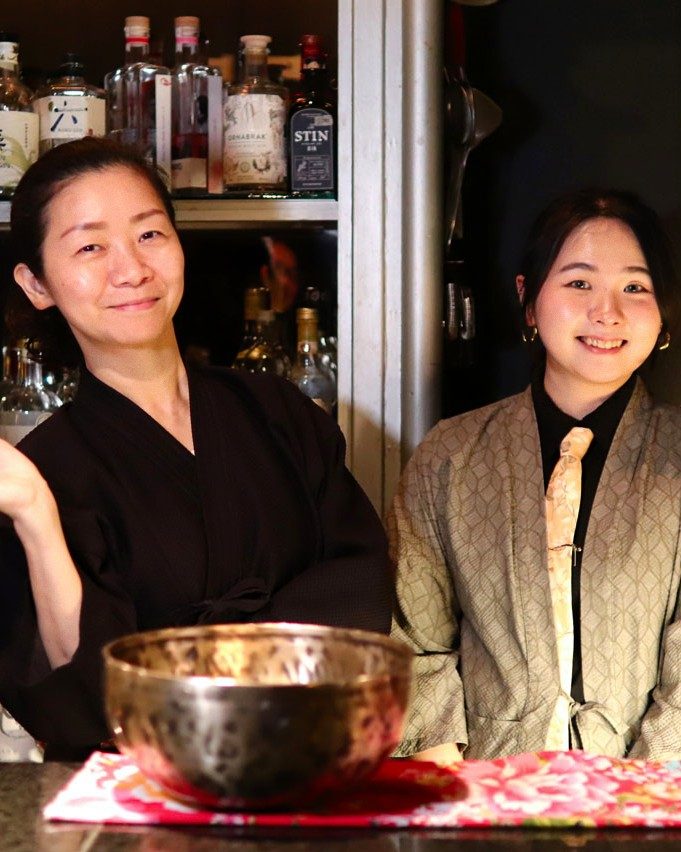 Two of the bar's staff in kimono behind the counter